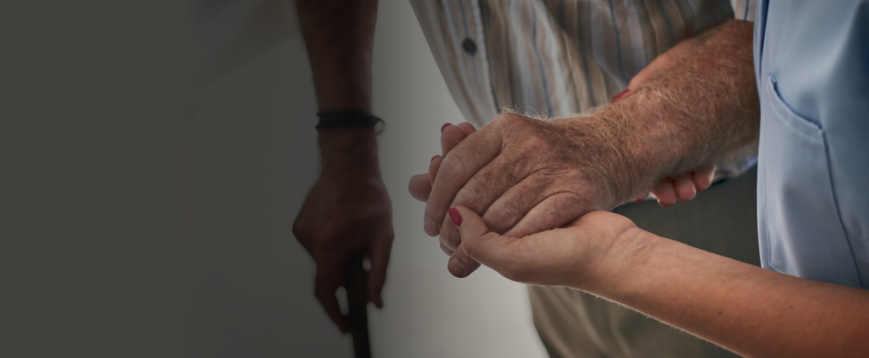 Elderly man's hand above younger's hand