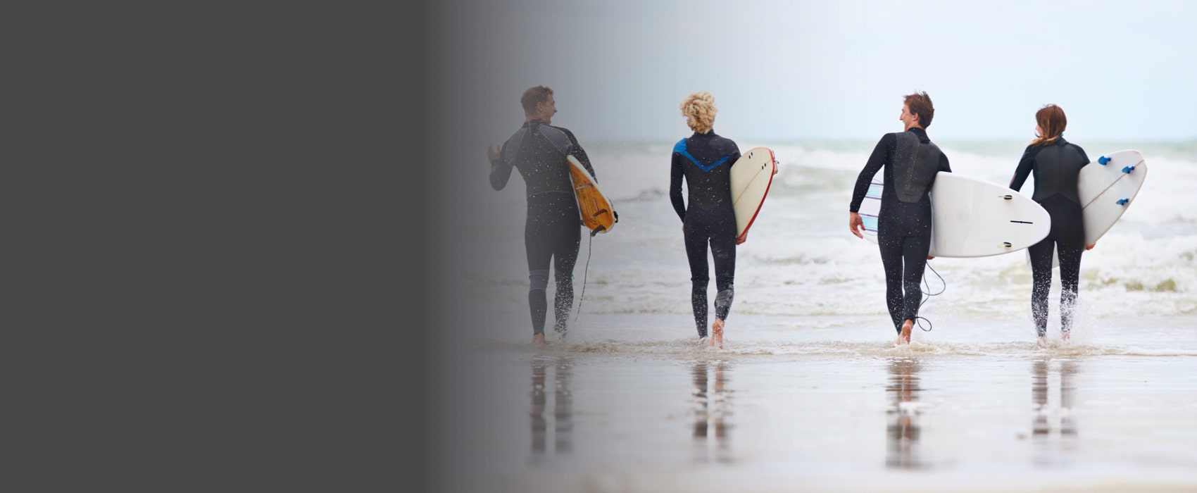 Four people going in the ocean for surfifying