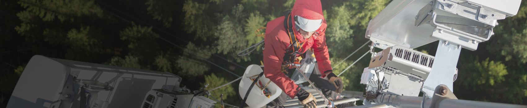 Men with red jacket climbing on a transmission tower