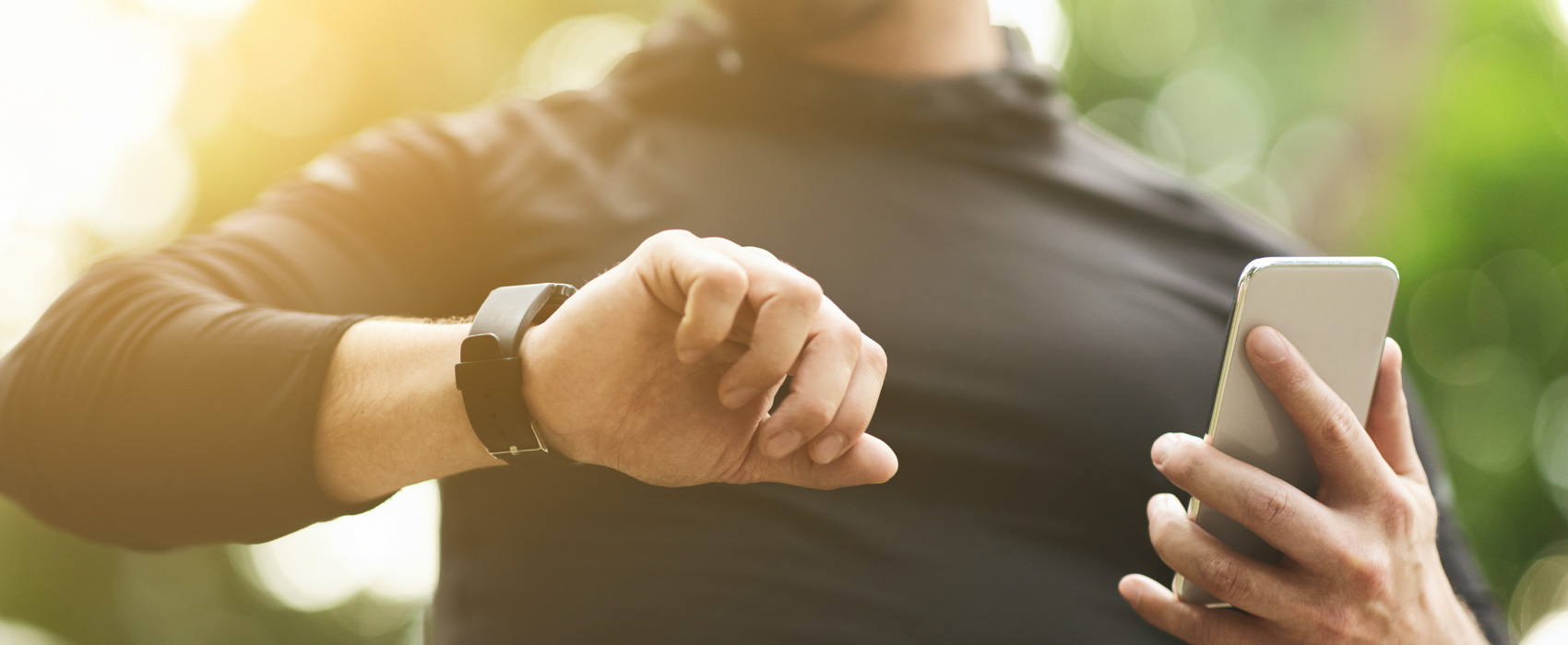 Man wearing a black t-shirt and watching at his wearable watch