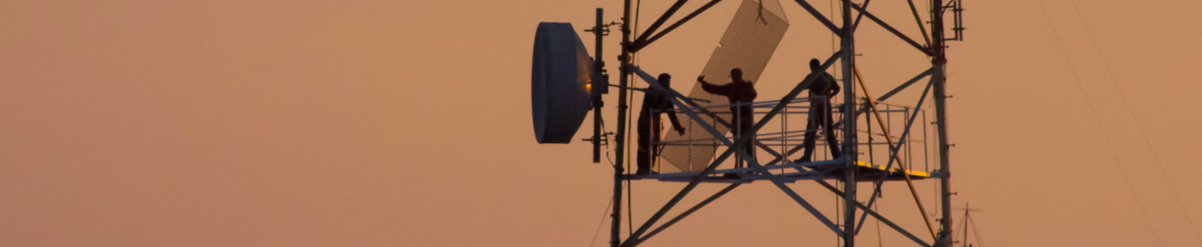 Three workers up on a transmission tower